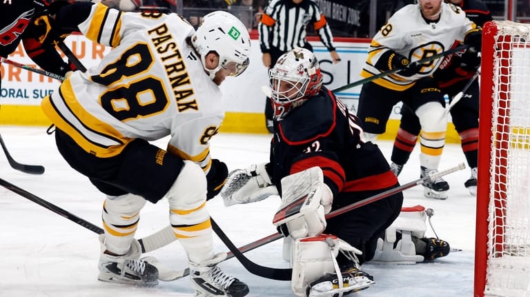 Boston Bruins' David Pastrnak (88) has his shot blocked by...