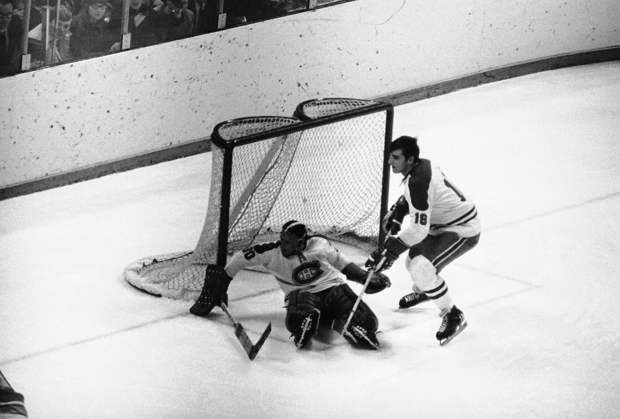 Montreal goalie Rogie Vachon looks for the puck next to defenseman Serge Savard.
