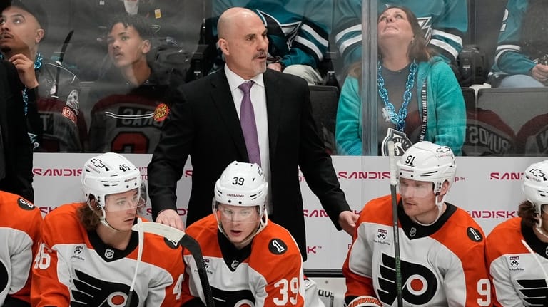 Philadelphia Flyers head coach Rick Tocchet, middle, watches from the...