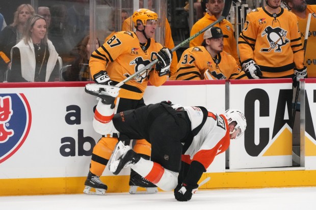 Penguins' Sidney Crosby (87) checks Flyers' Sean Couturier off his skates during the second period of Game 1 in the first round of the Stanley Cup playoffs in Pittsburgh, Saturday. The Flyers won 3-2 to take a 1-0 lead in the series. (AP Photo/Gene J. Puskar)