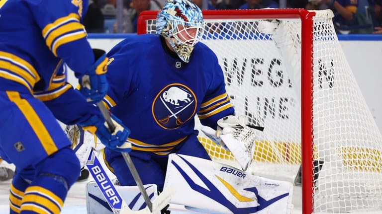 Buffalo Sabres goaltender Ukko-Pekka Luukkonen, right, watches the puck go...