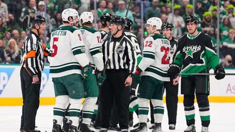 Minnesota Wild and Dallas Stars players are separated by officials...
