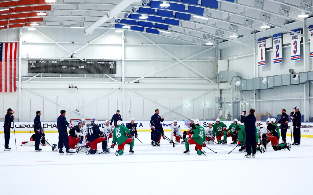 New York Rangers rookies kneeling on the ice during training camp.
