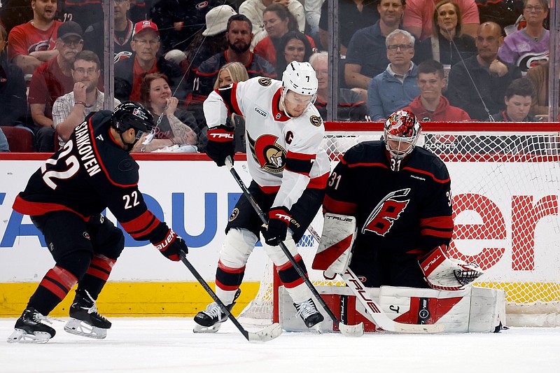 Carolina Hurricanes goaltender Frederik Andersen (31) blocks a shot by Ottawa Senators' Brady Tkachuk (7) with Hurricanes' Logan Stankoven (22) nearby during the second period of an Game 1 of an NHL hockey Stanley Cup first-round playoff series in Raleigh, N.C., Saturday, April 18, 2026. (AP Photo/Karl DeBlaker)
