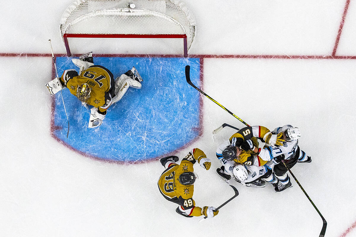 Golden Knights defenseman Jeremy Lauzon (5) fights with Utah Mammoth left wing Brandon Tanev (1 ...