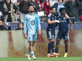 Brian White of the Vancouver Whitecaps FC celebrates with teammate Emmanuel Sabbi #11 after scoring a goal as Devin Padelford #2 of the Minnesota United reacts during the first half of MLS action at B.C. Place on Sunday
