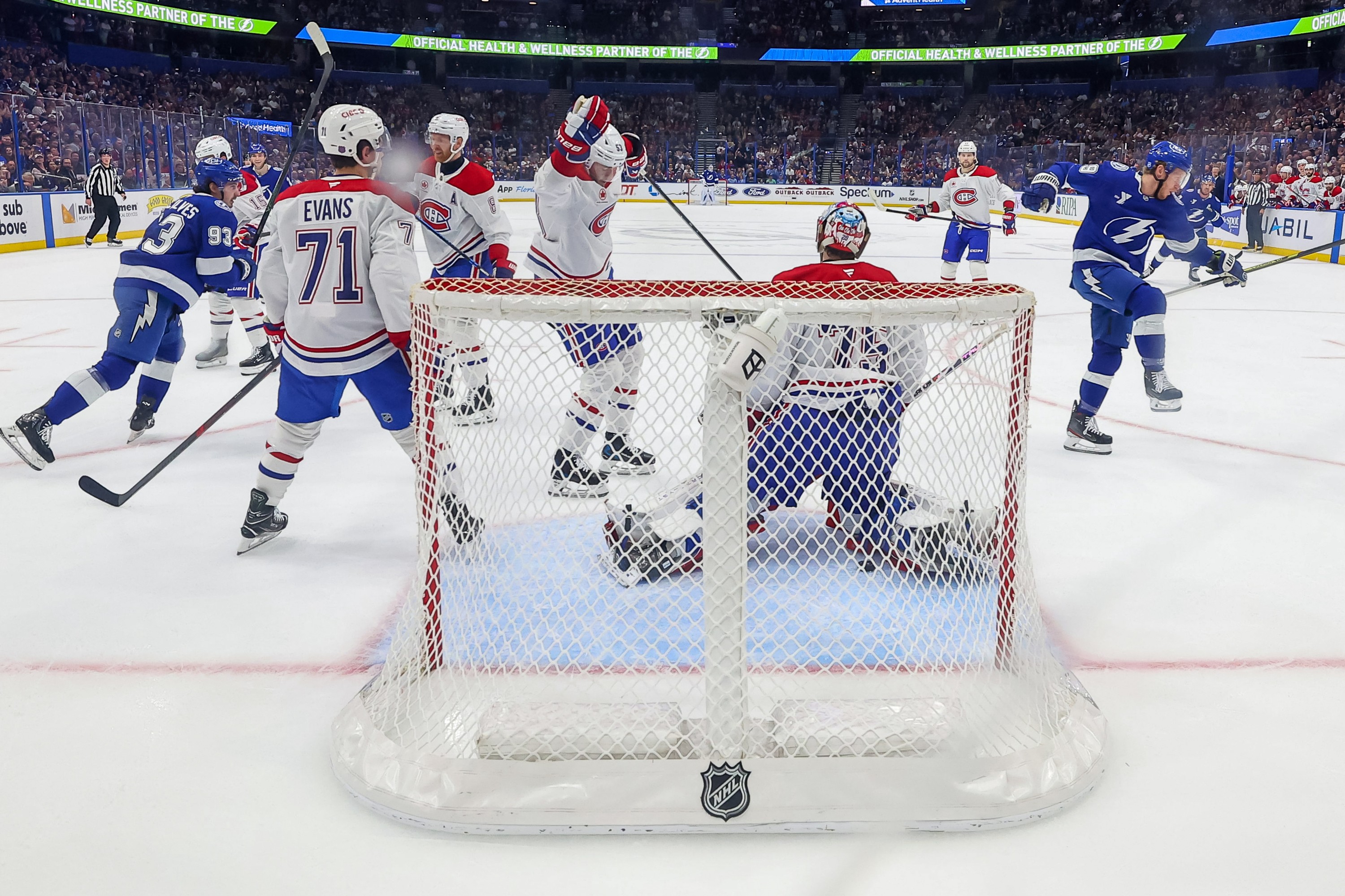Canadiens players look dejected while Lightning players celebrate in front of the Canadiens net