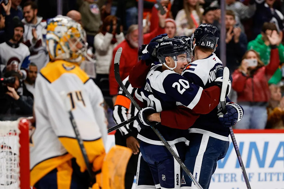 Dec 14, 2024; Denver, Colorado, USA; Colorado Avalanche center Ross Colton (20) celebrates his goal with right wing Valeri Nichushkin (13) as Nashville Predators goaltender Juuse Saros (74) looks on in the second period at Ball Arena. Mandatory Credit: Isaiah J. Downing-Imagn Images