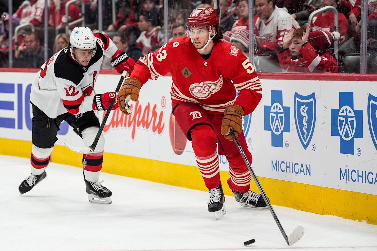 Detroit Red Wings defenseman Moritz Seider (53) looks to pass the puck against New Jersey Devils center Cody Glass (12) during the second period at Little Caesars Arena in Detroit on Saturday, April 11, 2026.