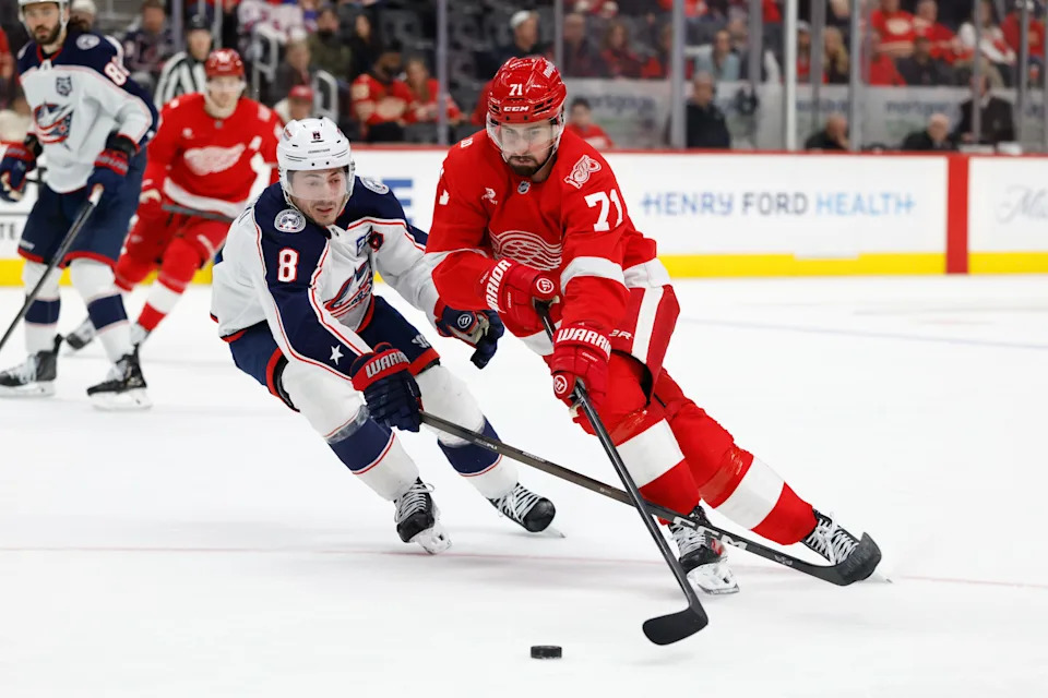 Apr 7, 2026; Detroit, Michigan, USA; Detroit Red Wings center Dylan Larkin (71) skates with the puck in overtime defended by Columbus Blue Jackets defenseman Zach Werenski (8) at Little Caesars Arena. Mandatory Credit: Rick Osentoski-Imagn Images