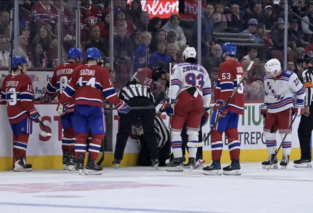 New York Rangers and Montreal Canadiens players gather around injured linesman Scott Cherrey (50) during the third period at the Bell Centre.