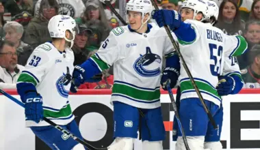 Vancouver Canucks defensemen Tom Willander (5) celebrates his goal against the Minnesota Wild with forward Max Sasson (63) and forward Teddy Blueger (53) during the first period at Grand Casino Arena.