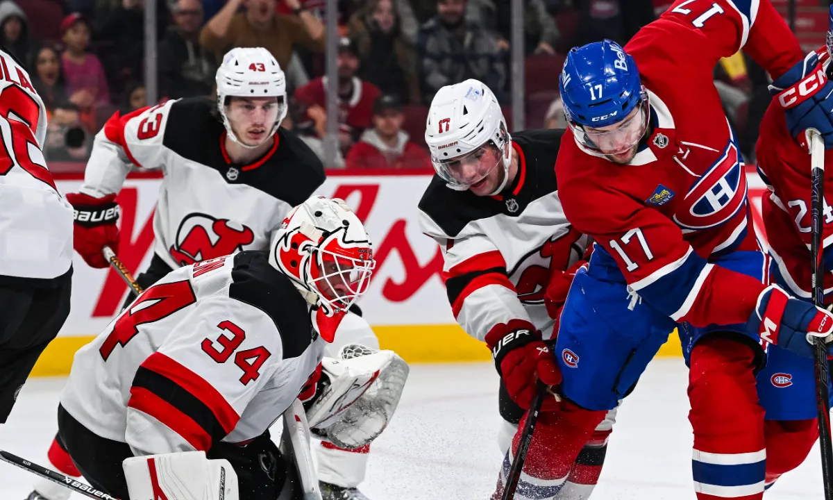 Montreal Canadiens defenseman Logan Mailloux (24) plays the puck beside right wing Josh Anderson (17) against New Jersey Devils goalie Jake Allen (34) during the second period at Bell Centre.