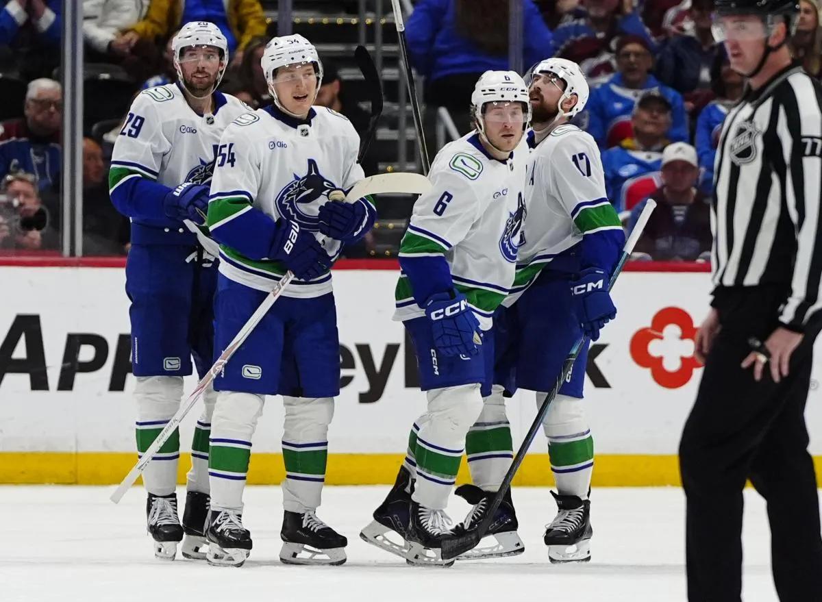 Members of the Vancouver Canucks celebrate a third period empty net goal by right wing Brock Boeser (6) against the Colorado Avalanche at Ball Arena.