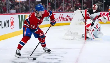 Montreal Canadiens right wing Cole Caufield (13) plays the puck near the net against the New Jersey Devils during the third period at Bell Centre.