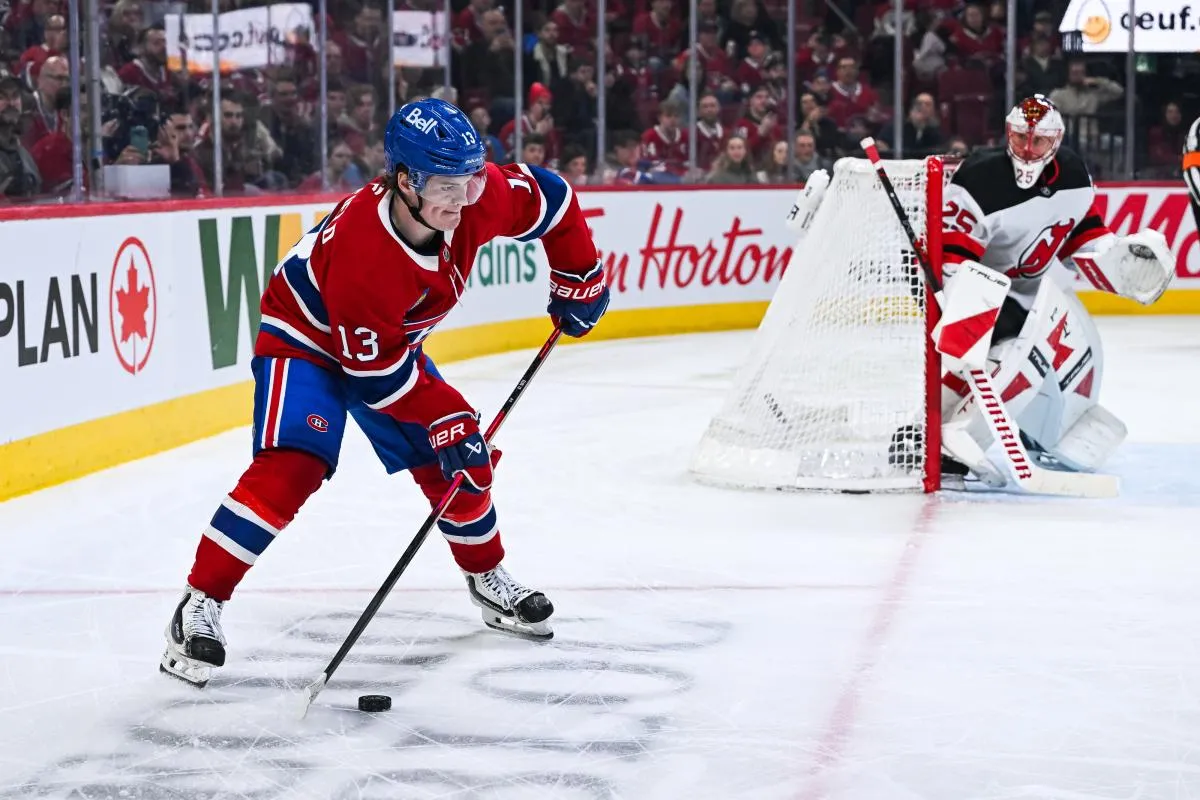 Montreal Canadiens right wing Cole Caufield (13) plays the puck near the net against the New Jersey Devils during the third period at Bell Centre.
