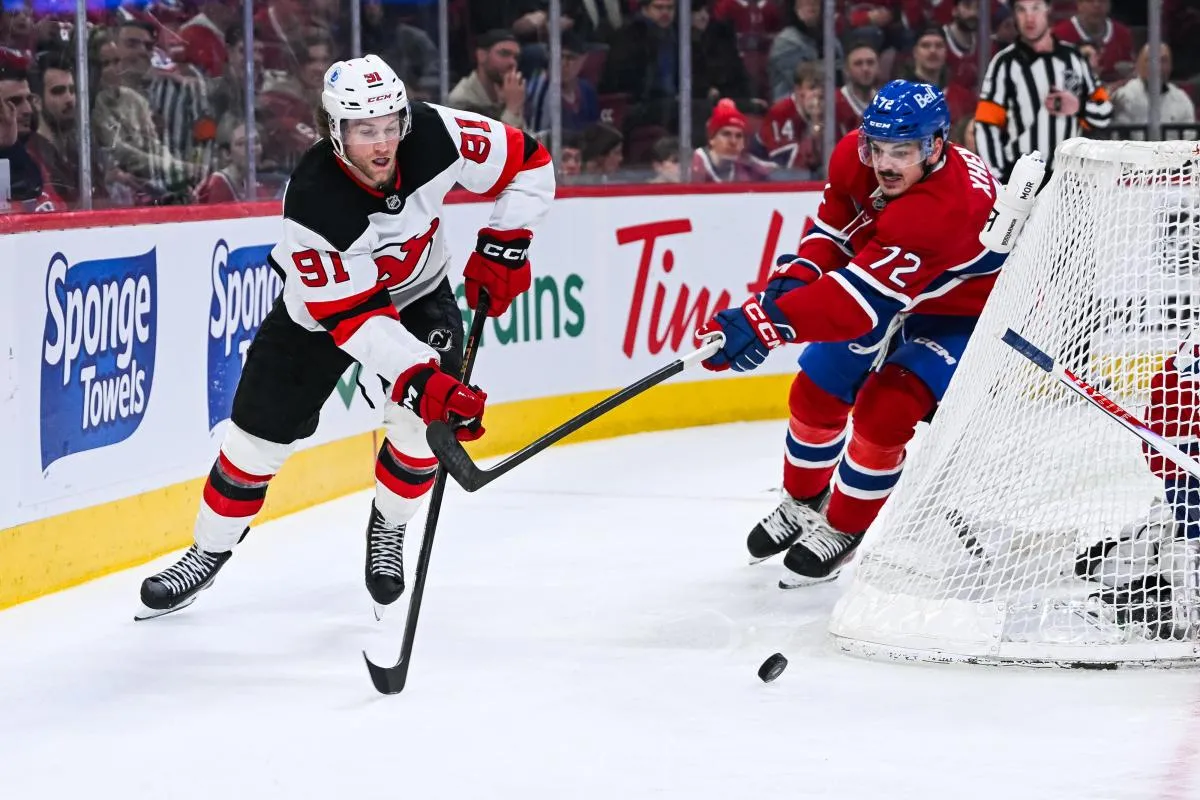 New Jersey Devils center Dawson Mercer (91) plays the puck against Montreal Canadiens defenseman Arber Xhekaj (72) during the second period at Bell Centre.