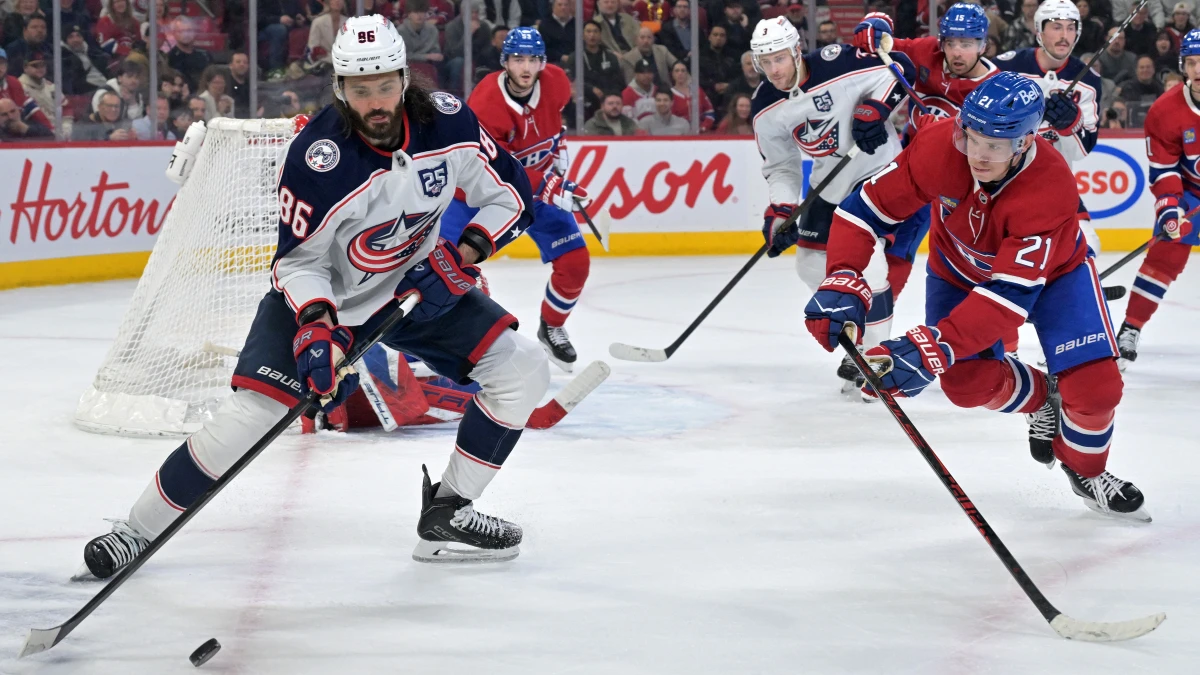 Columbus Blue Jackets forward Kirill Marchenko (86) plays the puck and Montreal Canadiens defenseman Kaiden Guhle (21) defends during the third period at the Bell Centre.