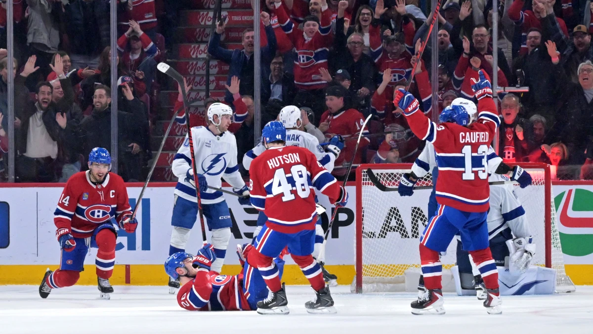 Montreal Canadiens forward Juraj Slafkovsky (20) celebrates with teammates including forward Cole Caufield (13) and forward Nick Suzuki (14) after scoring a goal against the Tampa Bay Lightning during the third period at the Bell Centre.