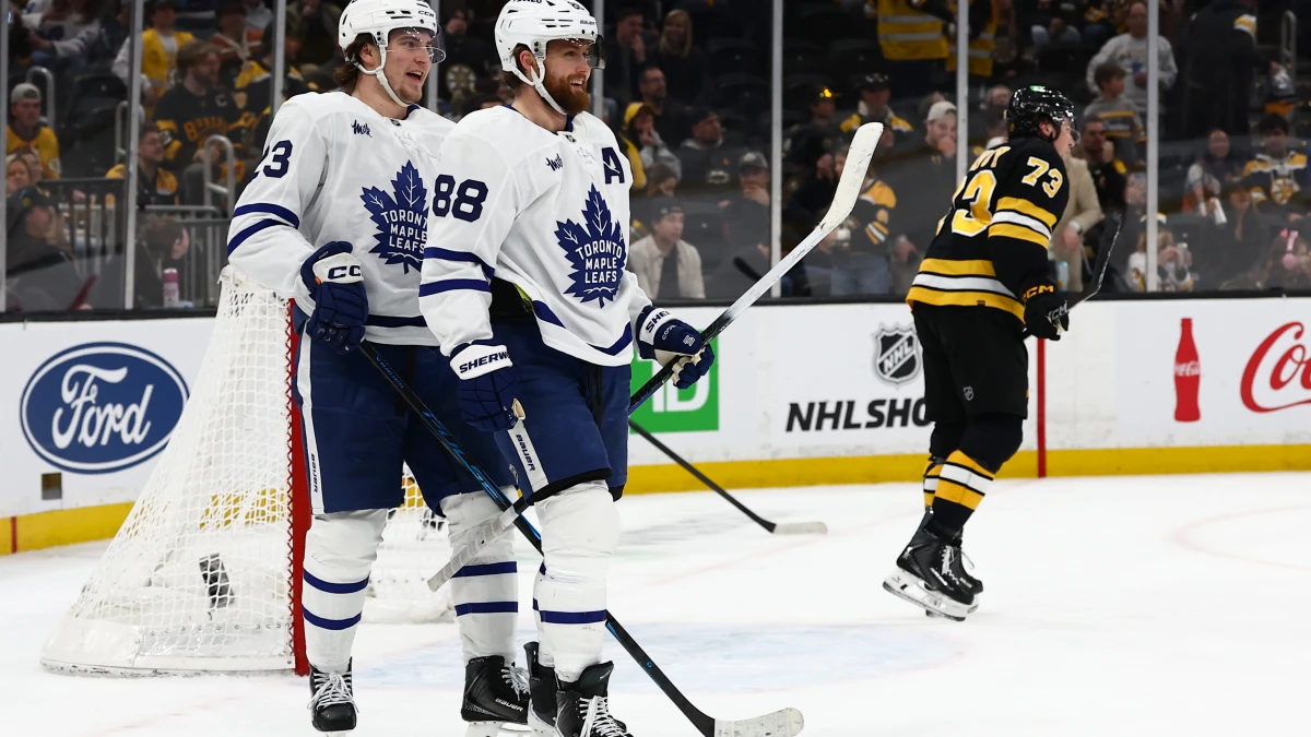 As Boston Bruins defenseman Charlie McAvoy (73) skates away, Toronto Maple Leafs right wing William Nylander (88) smiles with left wing Matthew Knies (23) after Knies scored during the third period at TD Garden.