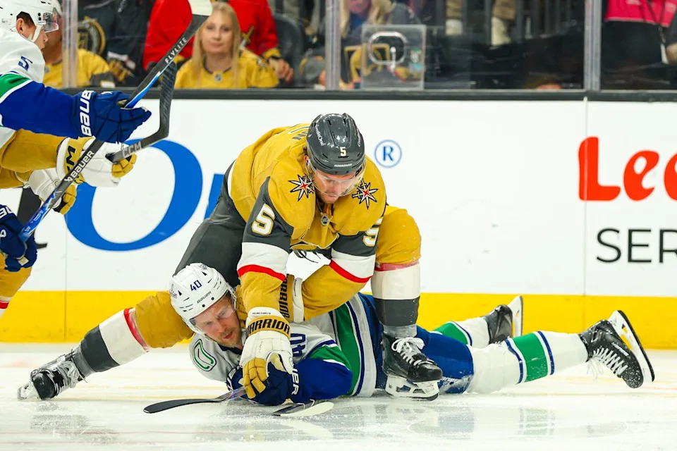 Vegas Golden Knights D Jeremy Lauzon (5) skates overtop Vancouver Canucks F Elias Pettersson (40) after hitting him in the third period of an NHL game on Monday, March 30, 2026, in Las Vegas, Nevada.