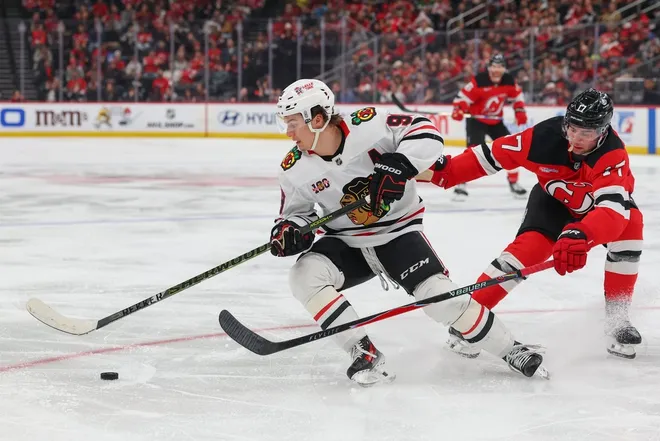 Mar 29, 2026; Newark, New Jersey, USA; Chicago Blackhawks center Connor Bedard (98) skates with the puck as New Jersey Devils defenseman Simon Nemec (17) defends during the third period at Prudential Center.