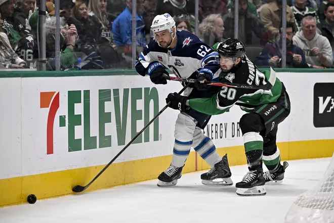 Feb 2, 2026; Dallas, Texas, USA; Winnipeg Jets right wing Nino Niederreiter (62) and Dallas Stars defenseman Kyle Capobianco (20) battle for control of the puck during the first period at the American Airlines Center.