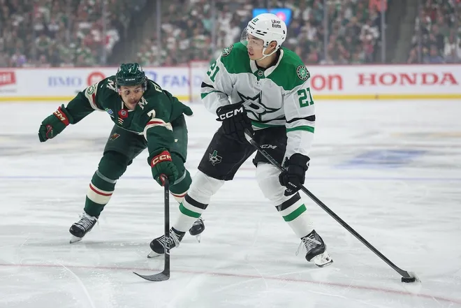 Apr 22, 2026; Saint Paul, Minnesota, USA; Dallas Stars left wing Jason Robertson (21) skates with the puck as Minnesota Wild defenseman Brock Faber (7) defends during the first period in game three of the first round of the 2026 Stanley Cup Playoffs at Grand Casino Arena.