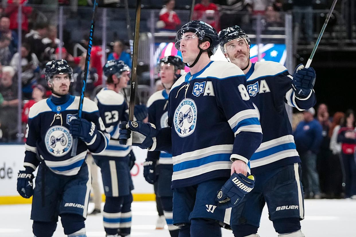 Columbus Blue Jackets defenseman Zach Werenski (8) and teammates salute the fans at center ice following the NHL hockey game against the Washington Capitals at Nationwide Arena in Columbus on April 14, 2026. The Blue Jackets lost 2-1.
