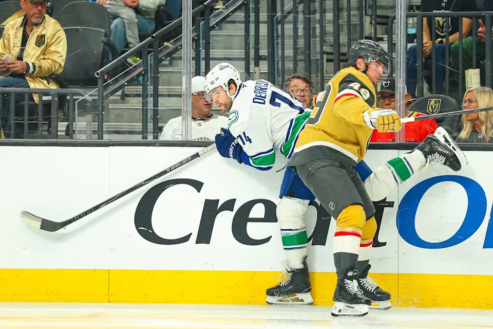 Vegas Golden Knights F Ivan Barbashev (49) lays a hit on Vancouver Canucks F Jake DeBrusk (74) on Monday, March 30, 2026, in Las Vegas, Nevada.