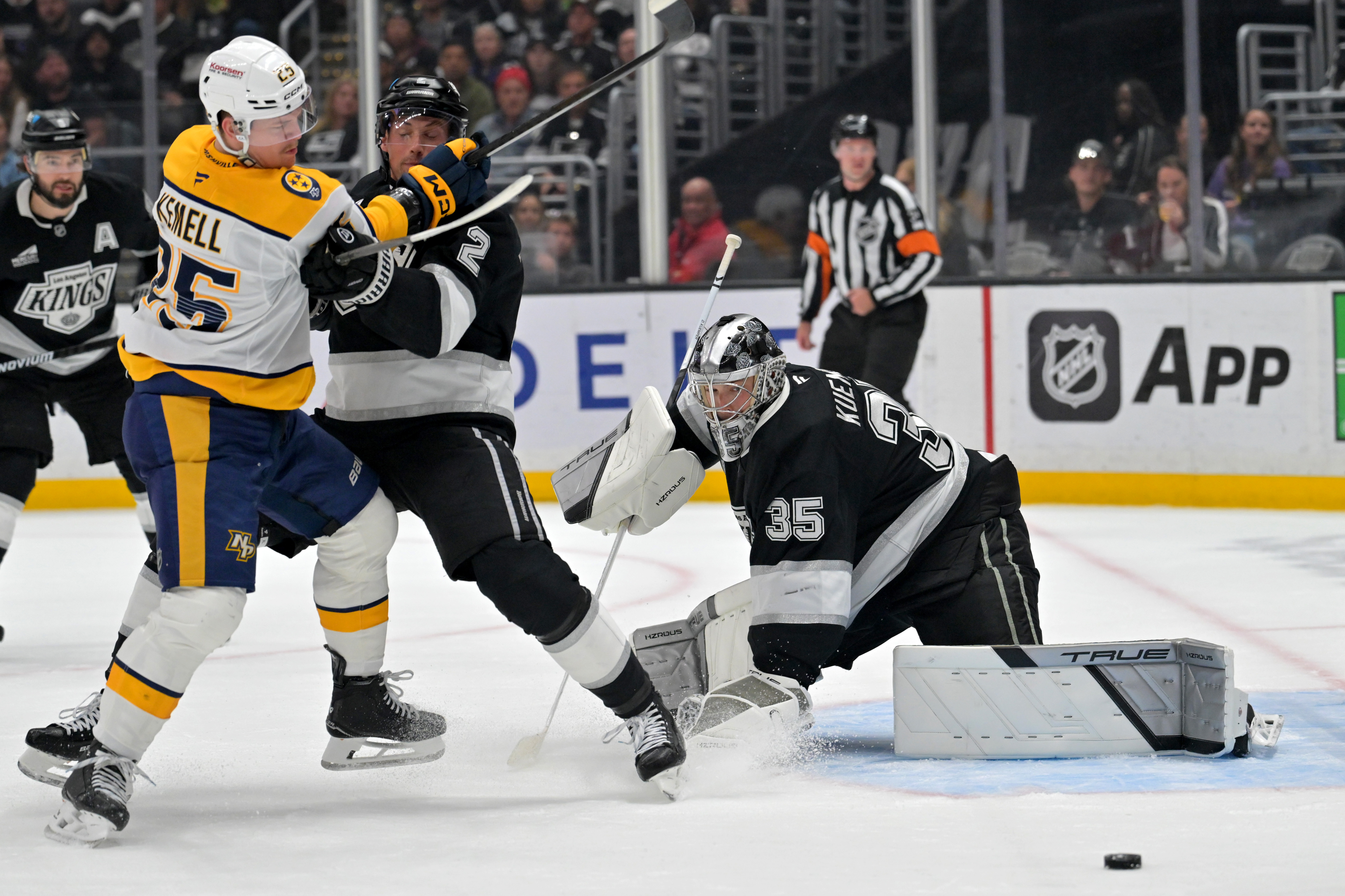 Kings goaltender Darcy Kuemper, right, defends the net as Nashville...