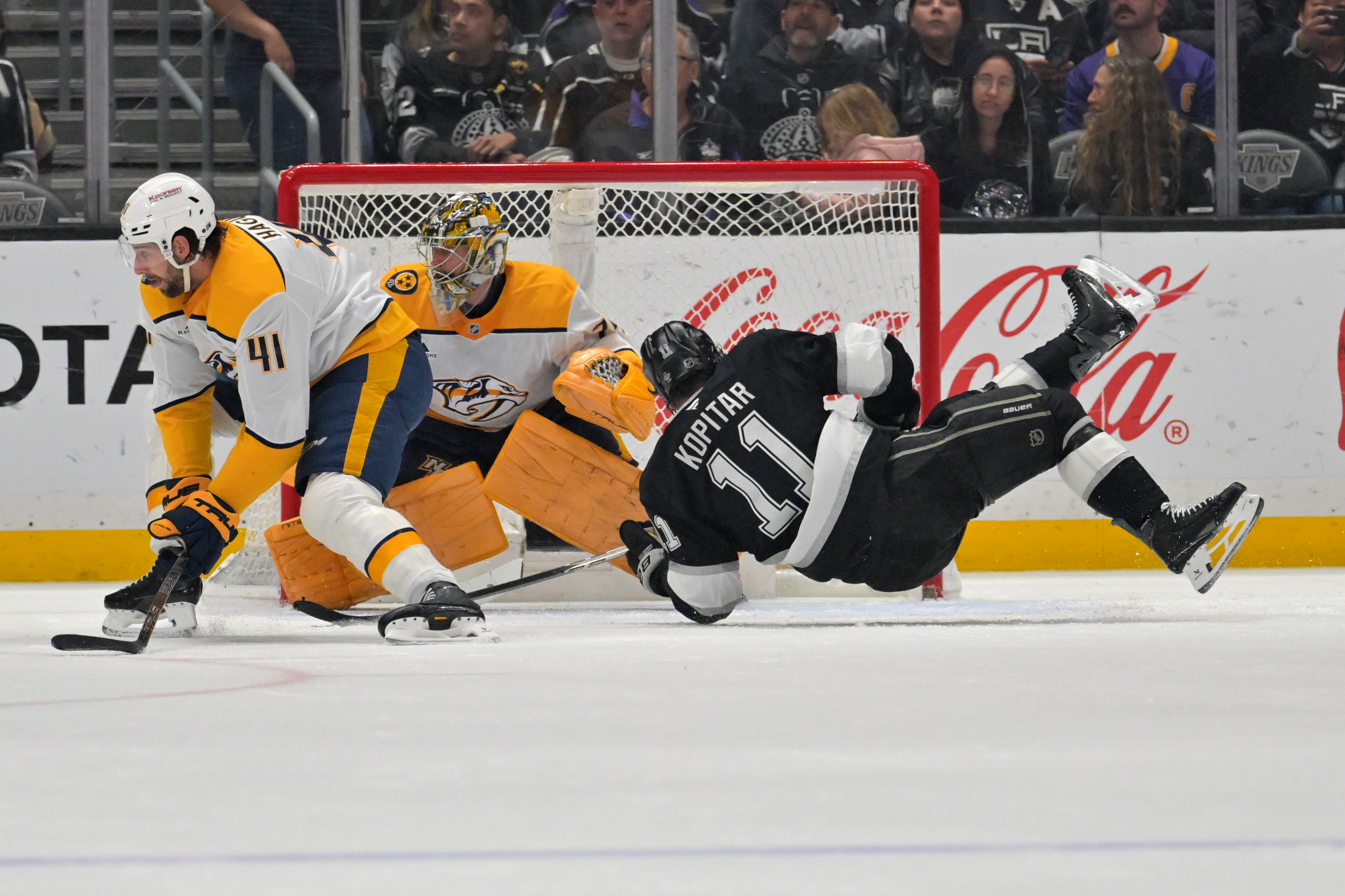 Kings center Anze Kopitar, right, is tripped by Nashville Predators...