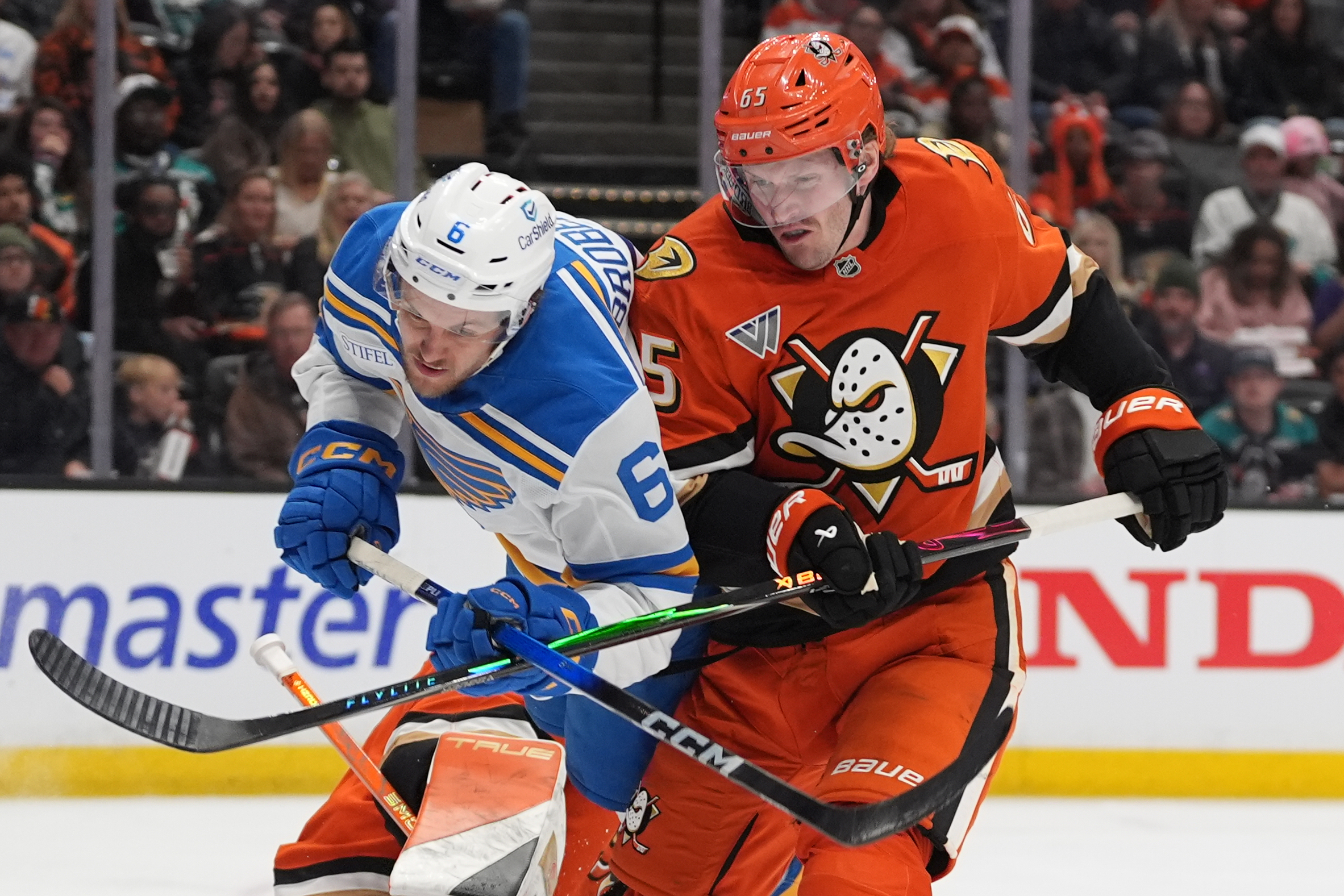 St. Louis Blues defenseman Philip Broberg, left, is brought down...