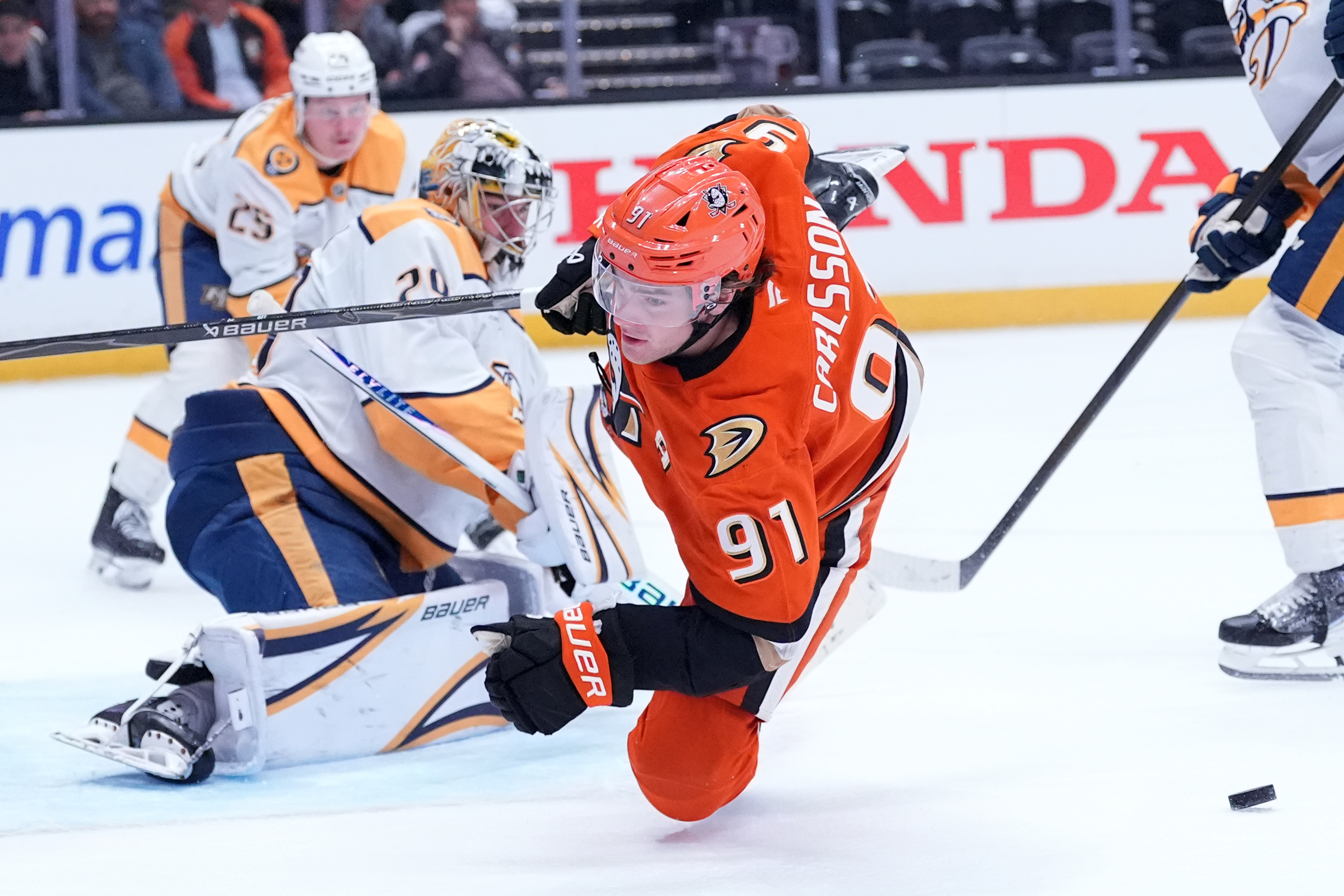 Ducks center Leo Carlsson falls to the ice after being...