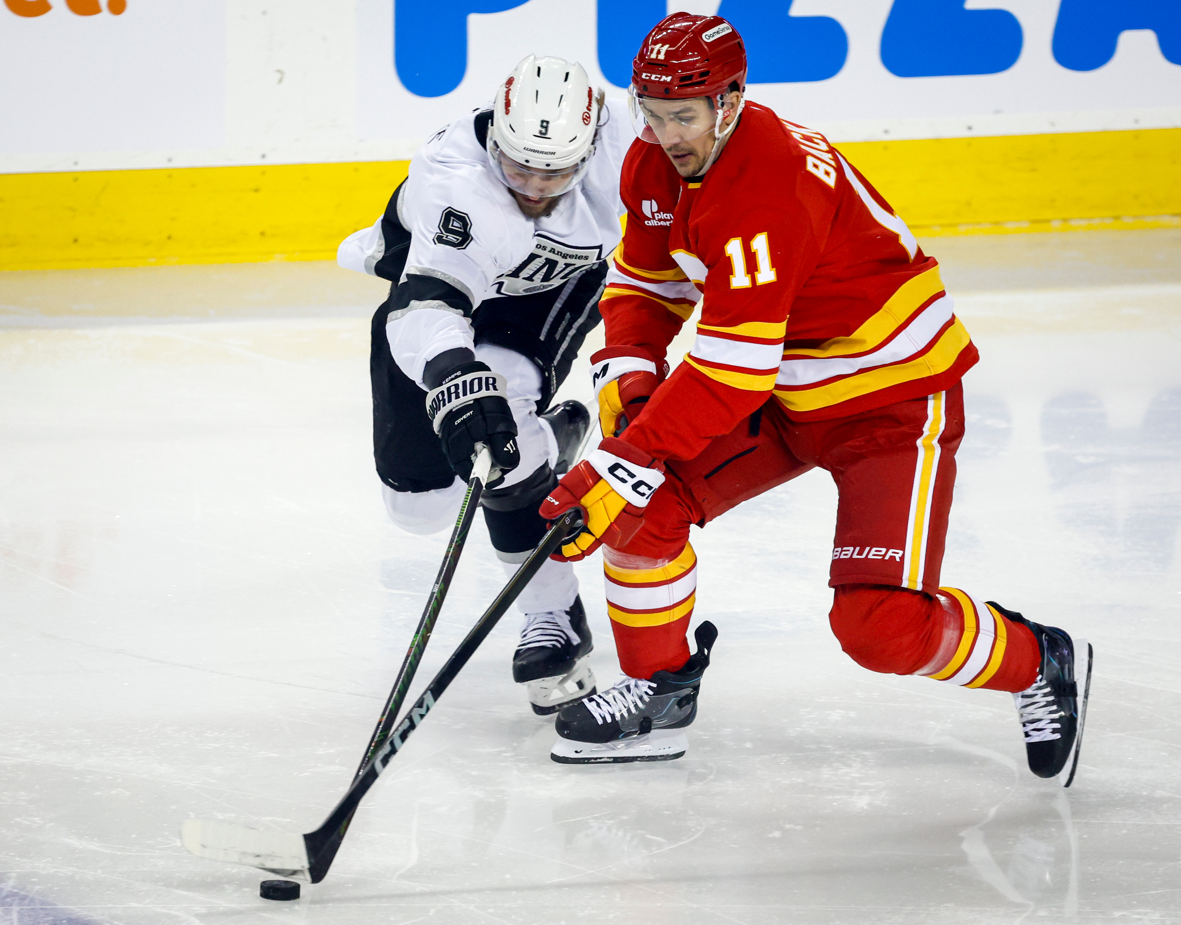 The Kings’ Adrian Kempe, left, and the Calgary Flames’ Mikael...