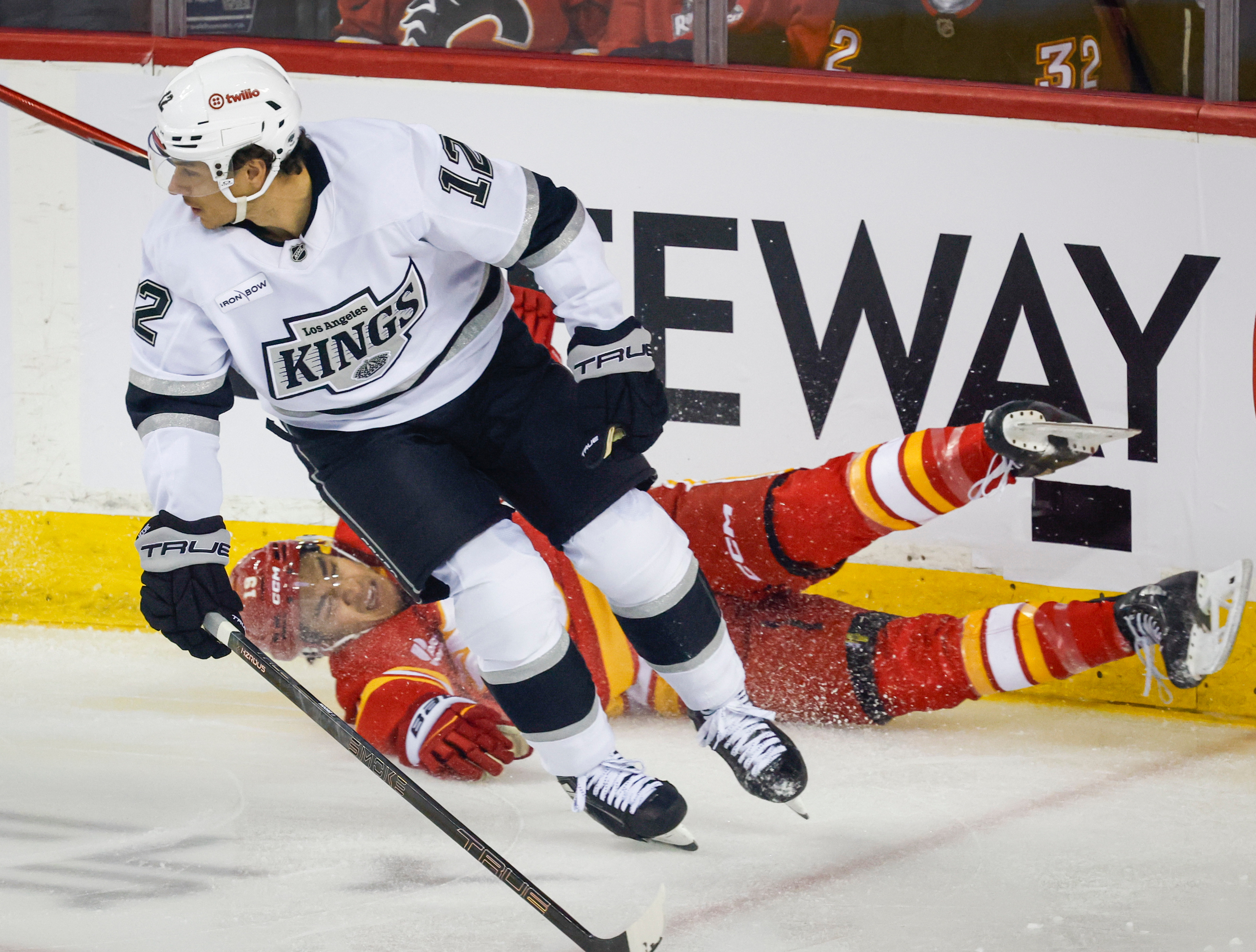 The Kings’ Trevor Moore, front, checks the Calgary Flames’ Zayne...