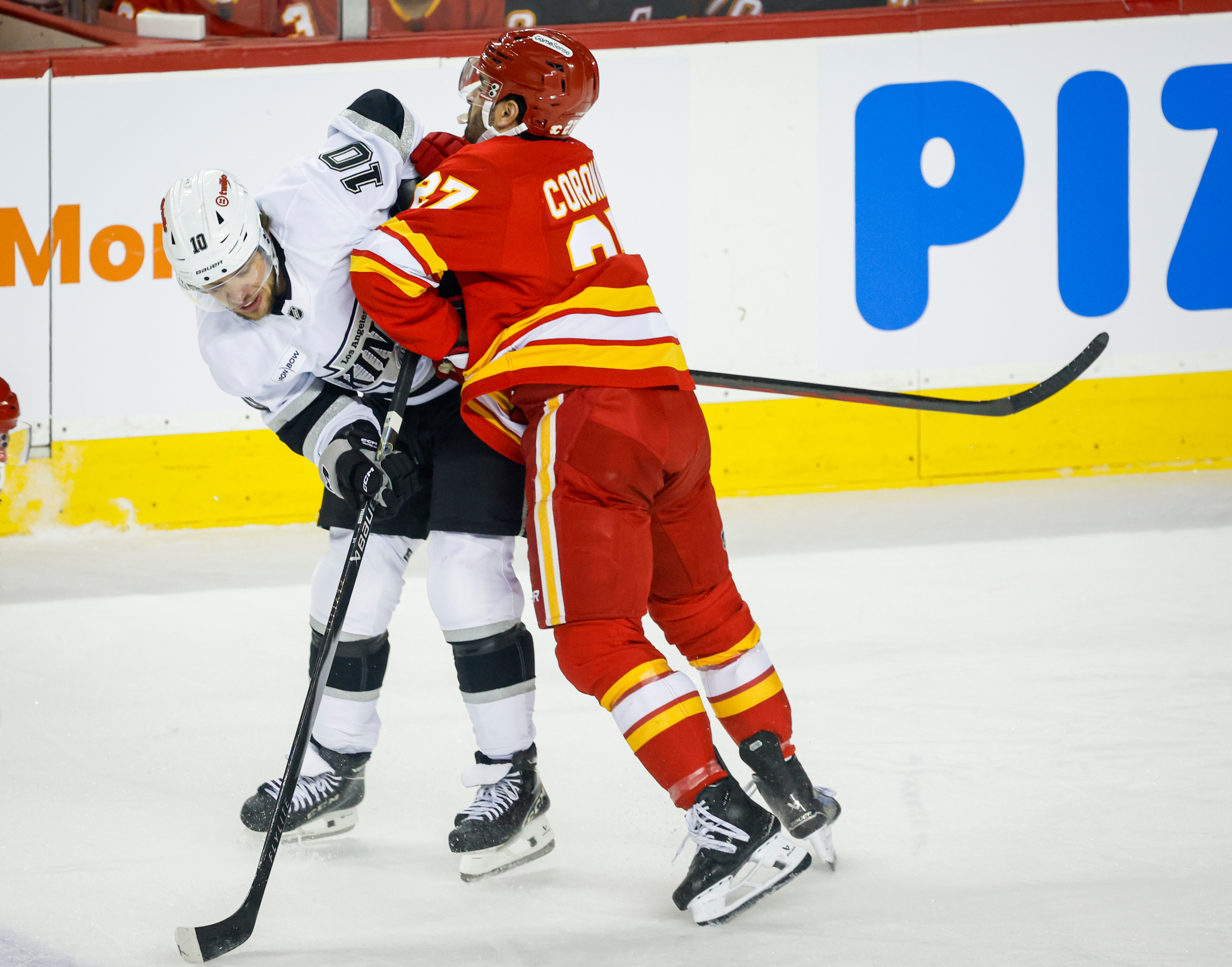 The Kings’ Artemi Panarin, left, is checked by the Calgary...