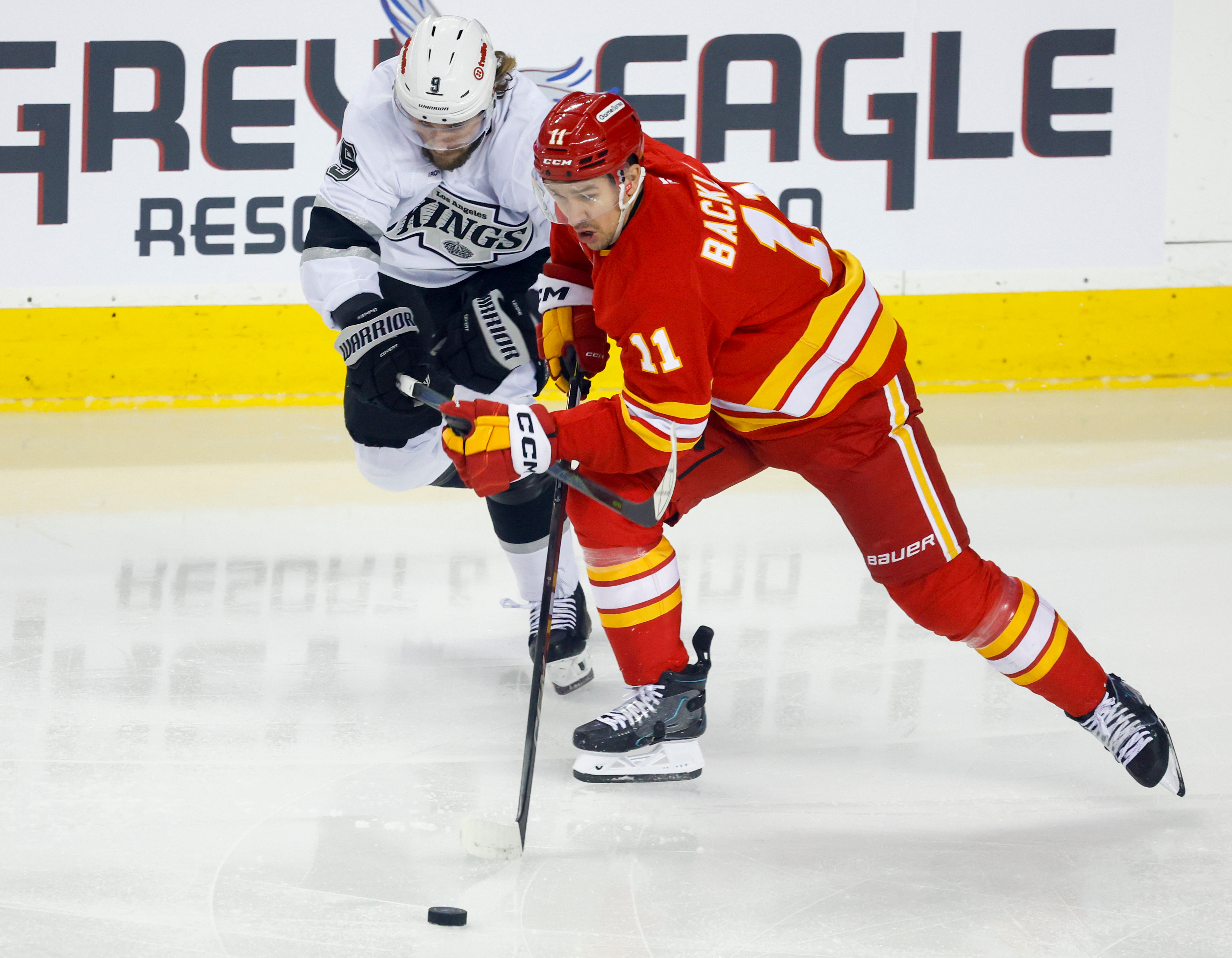 The Kings’ Adrian Kempe, left, and the Calgary Flames’ Mikael...