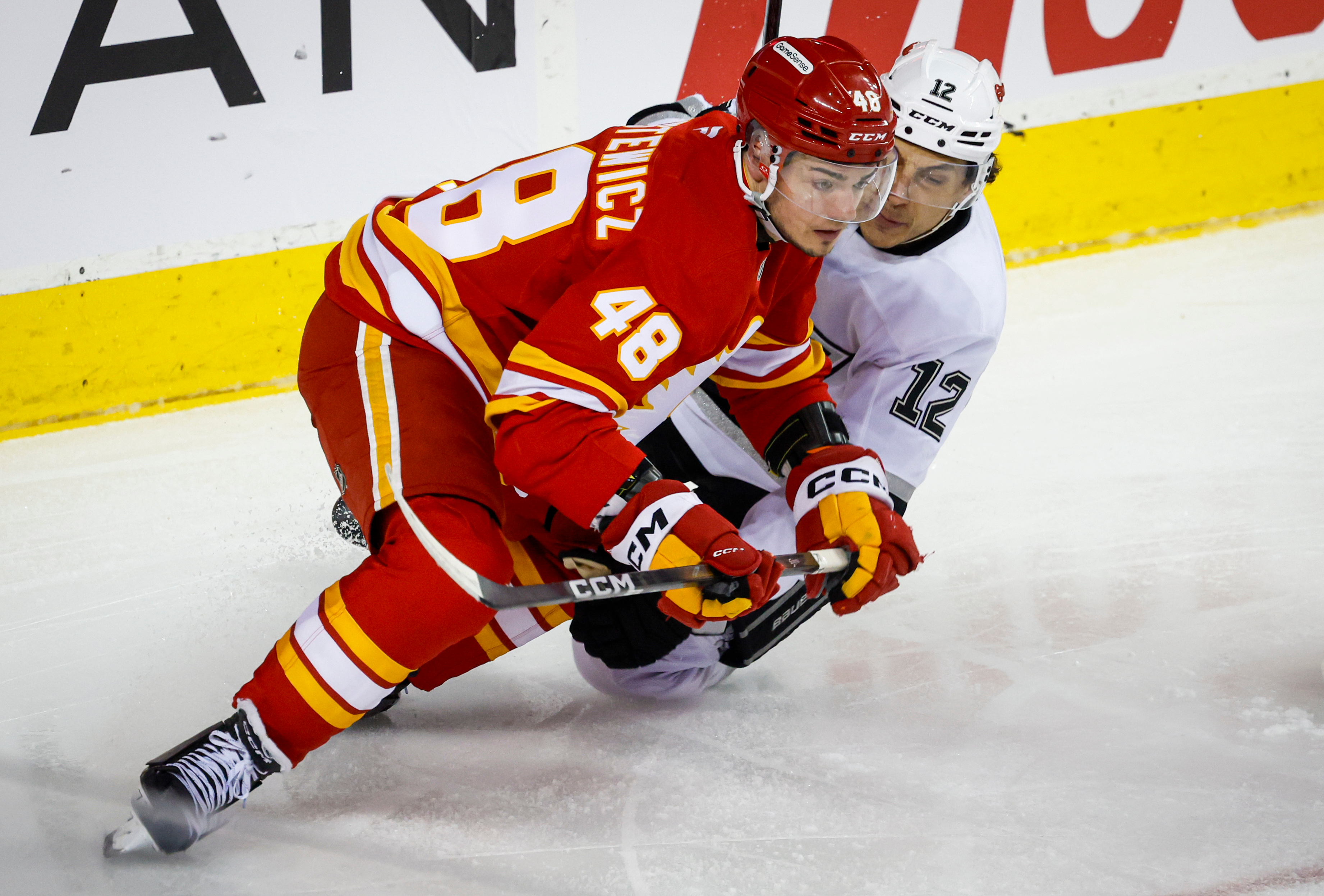 The Kings’ Trevor Moore, right, is checked by the Calgary...