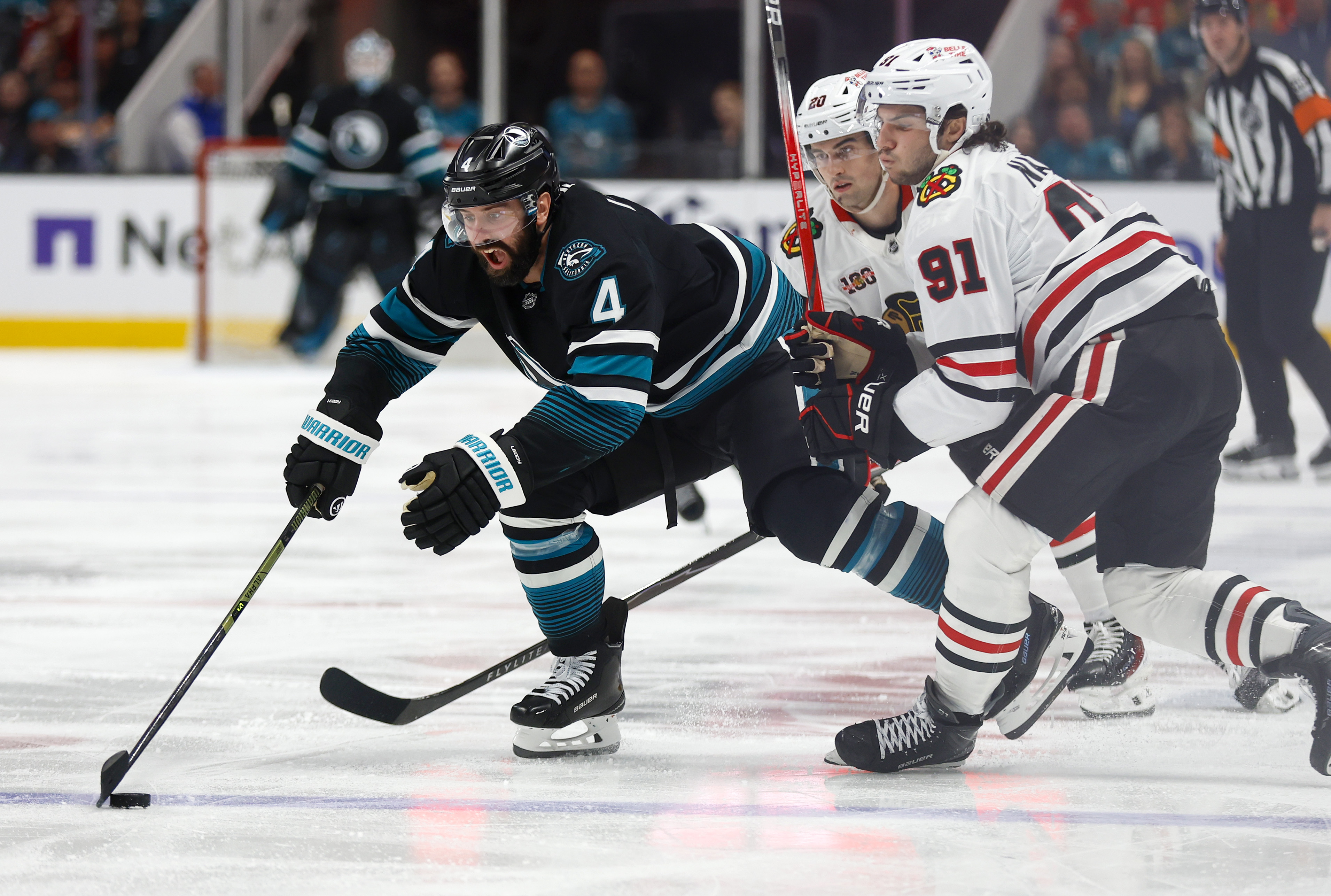 San Jose Sharks’ Nick Leddy (4) fights for the puck...