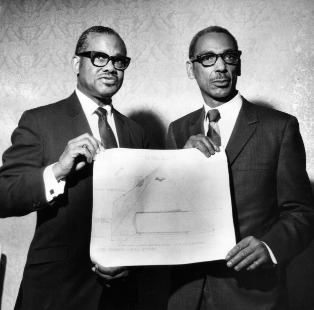 Rufus Stokes, scientist and inventor of a patented anti-air pollution system, right, and Leonidas H. Berry, lecturer and research physician in gastric cancer at Cook County Hospital, hold up a drawing of a pyramid on Jan. 15, 1971, at the annual awards dinner of the Council for Bio-Medical Careers in Chicago. (William Bender/Chicago Tribune)