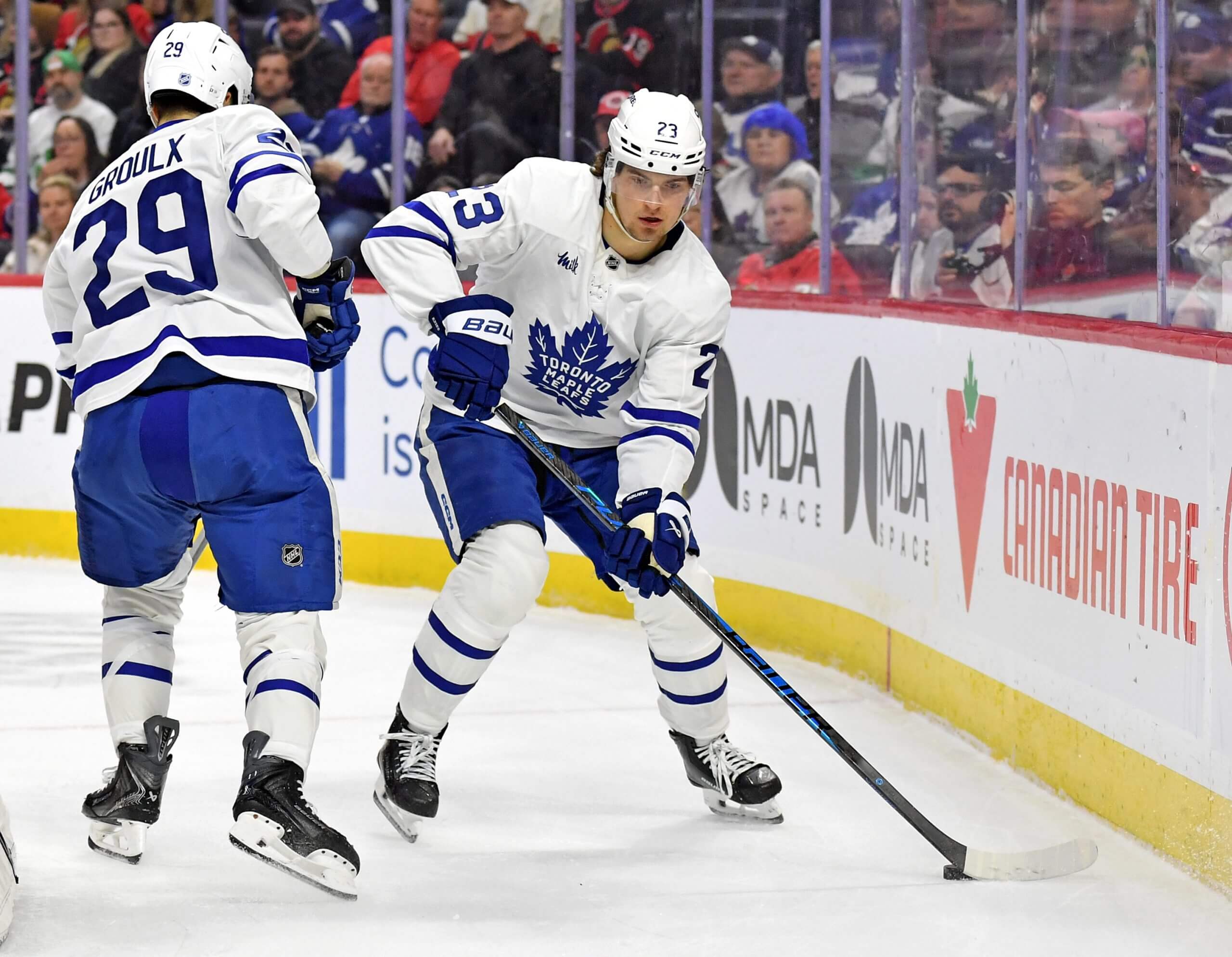 Matthew Knies skates with the puck while Leafs teammate Bo Groulx passes him in the other direction.