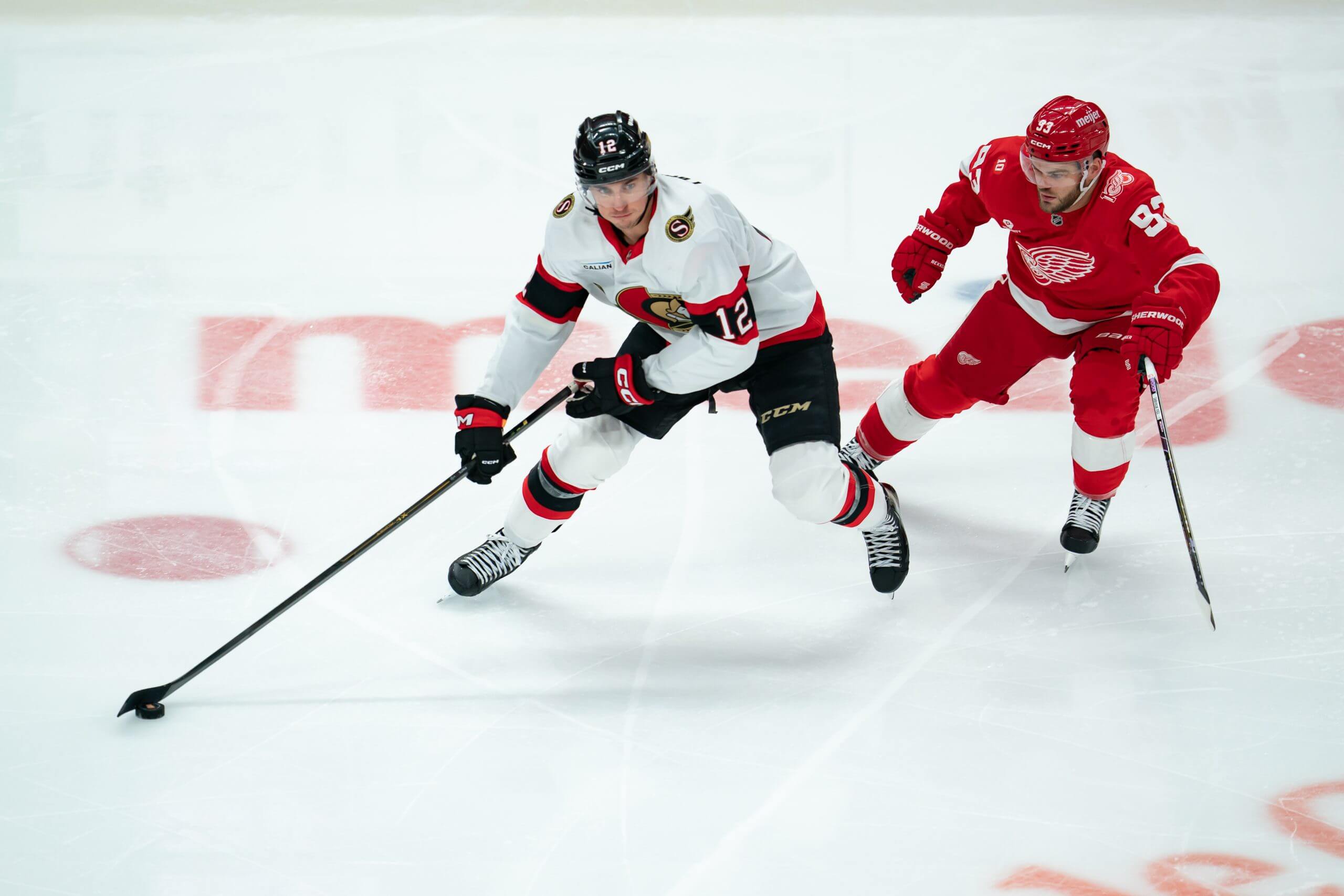 Ottawa's Shane Pinto keeps the puck away from a pursuing Alex DeBrincat