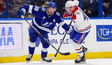 TAMPA, FL - MARCH 31: Brandon Hagel #38 of the Tampa Bay Lightning and Lane Hutson #48 of the Montréal Canadiens chase a loose puck during the first period at the Benchmark International Arena on March 31, 2026 in Tampa, Florida. (Photo by Mike Carlson/Getty Images)