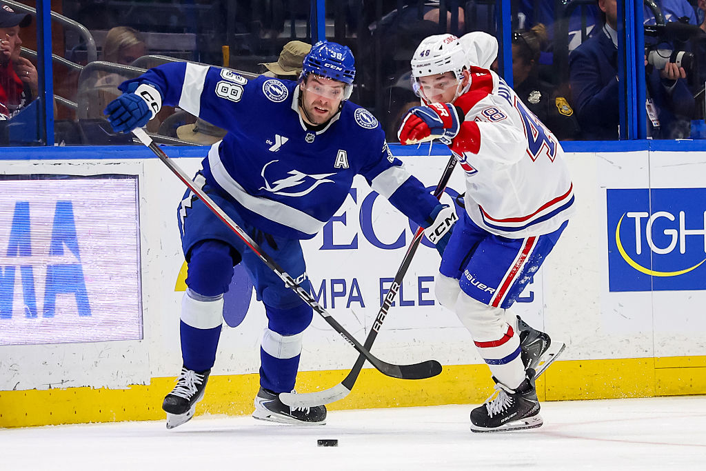 TAMPA, FL - MARCH 31: Brandon Hagel #38 of the Tampa Bay Lightning and Lane Hutson #48 of the Montréal Canadiens chase a loose puck during the first period at the Benchmark International Arena on March 31, 2026 in Tampa, Florida. (Photo by Mike Carlson/Getty Images)