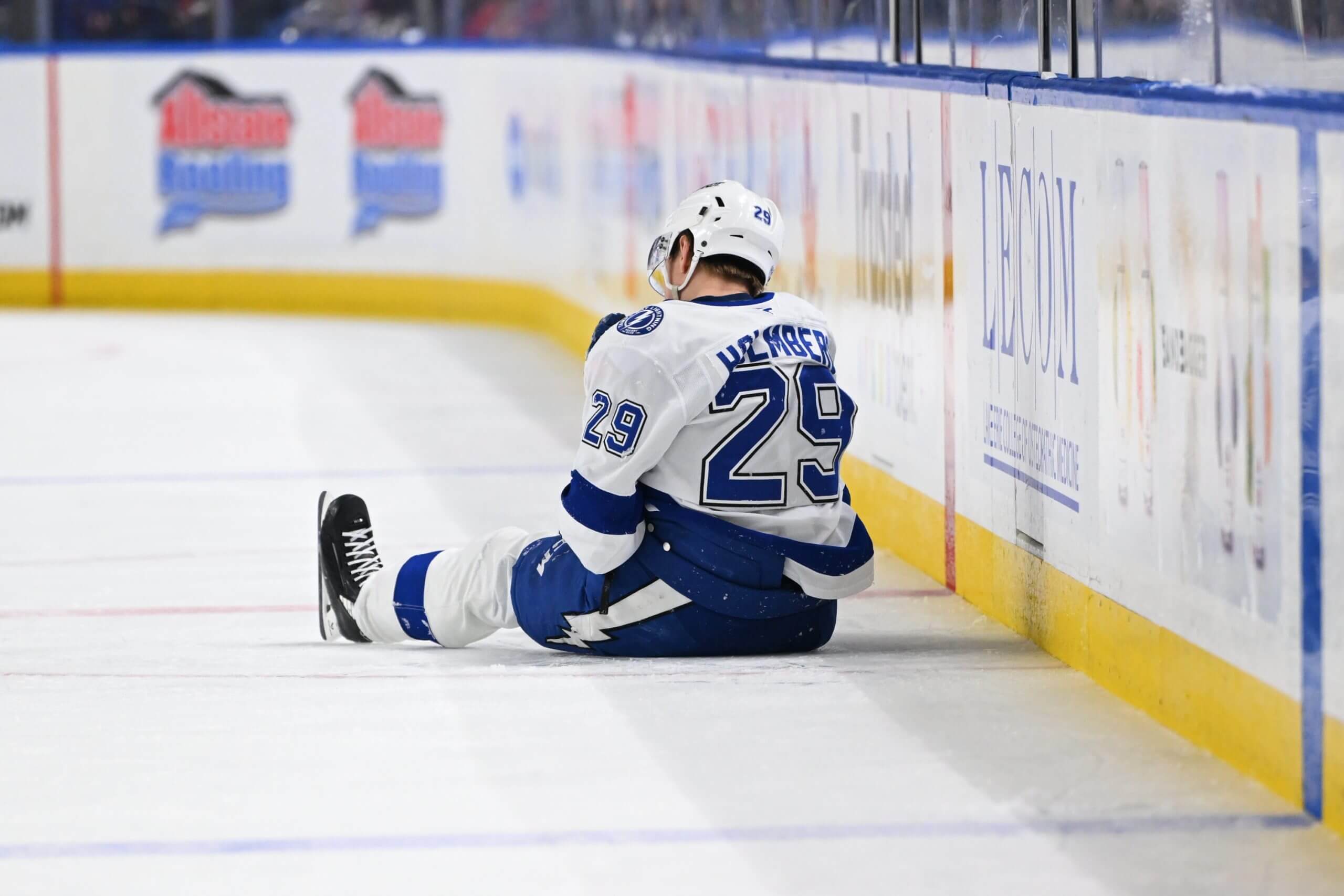 Pontus Holmberg, seen from behind, sits on the ice after colliding with the boards.