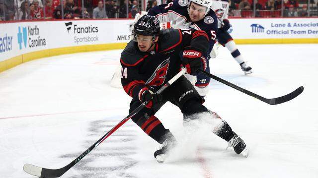 Seth Jarvis (24) of the Carolina Hurricanes protects the puck from Denton Mateychuk of the Columbus Blue Jackets during the second period of their game at Lenovo Center on April 2, 2026 in Raleigh, North Carolina.