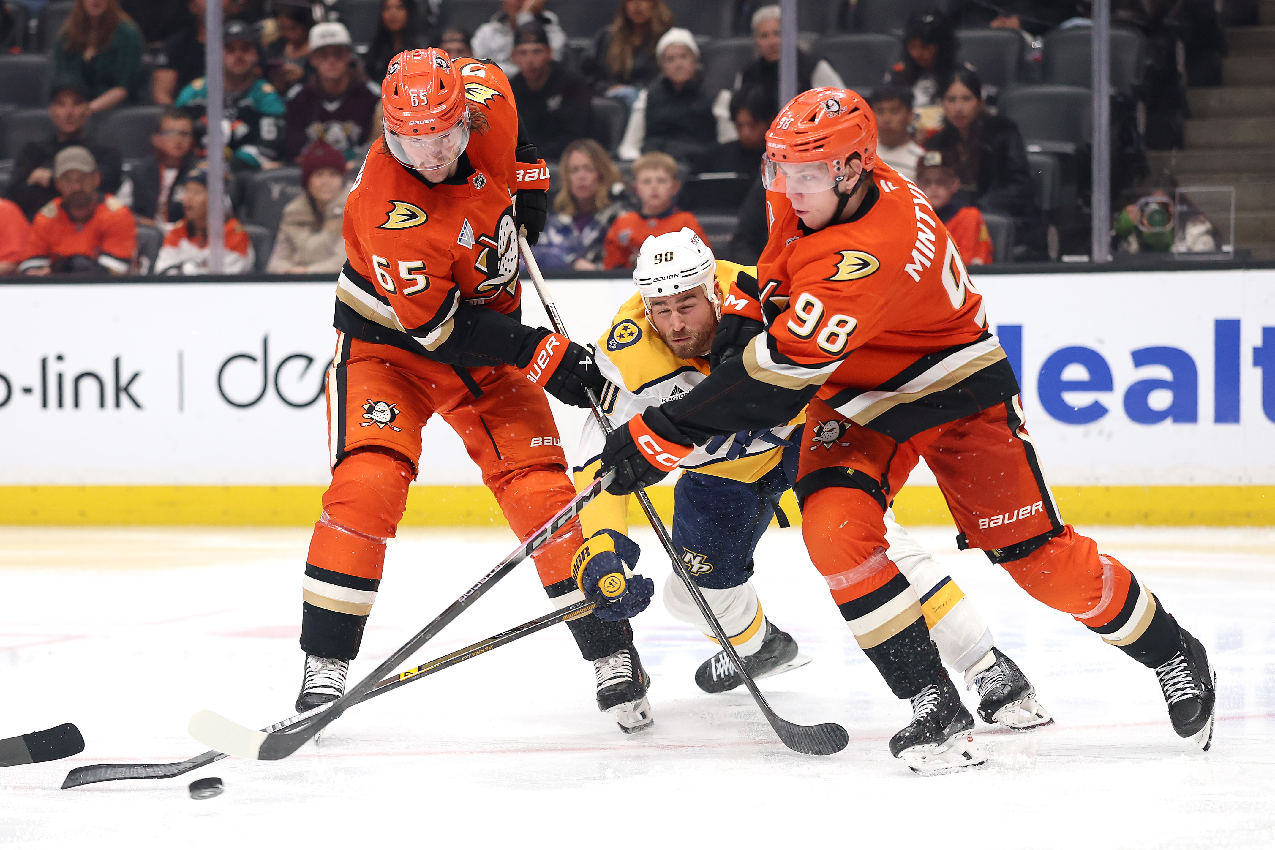 The Ducks’ Pavel Mintyukov, right, and Jacob Trouba, left, battle...