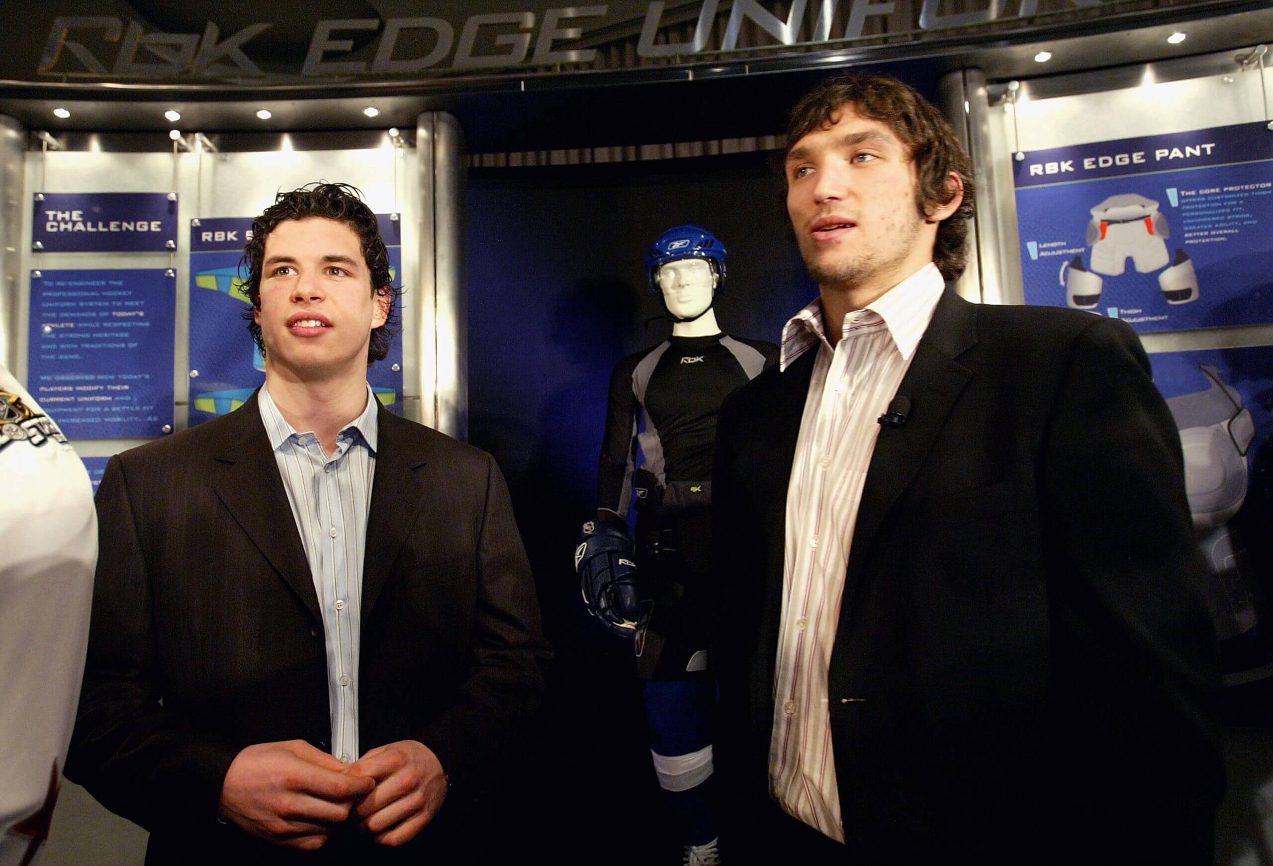 Crosby and Ovechkin stand in suits next to each other at a press event
