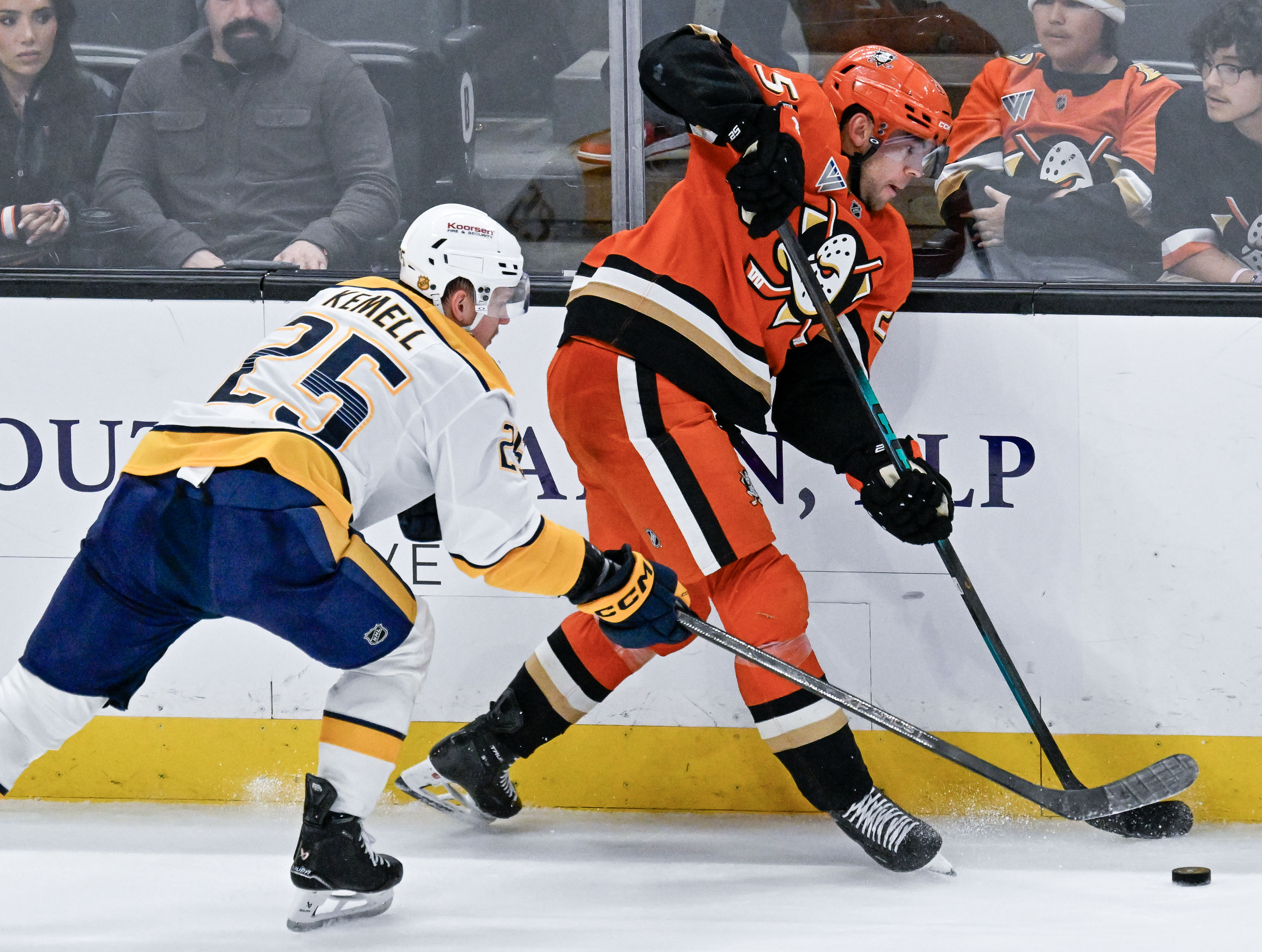 The Ducks’ Ryan Poehling, right, controls the puck in front...